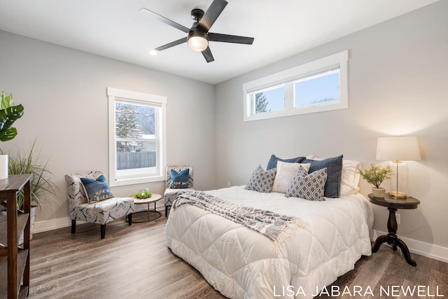 bedroom featuring ceiling fan, wood-type flooring, and multiple windows