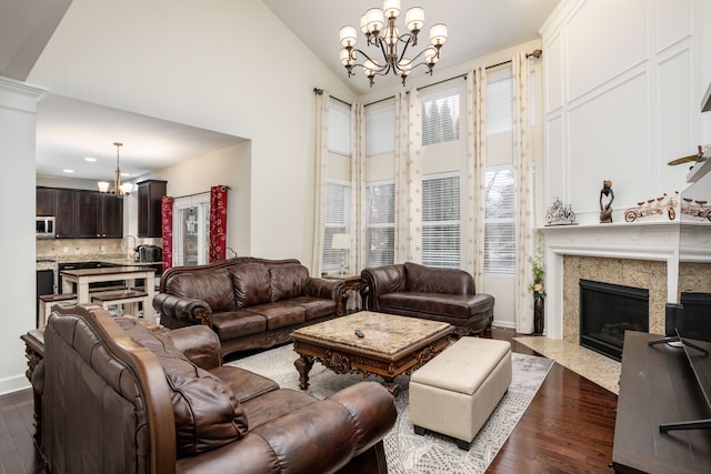 living room featuring a fireplace, dark hardwood / wood-style floors, and a notable chandelier