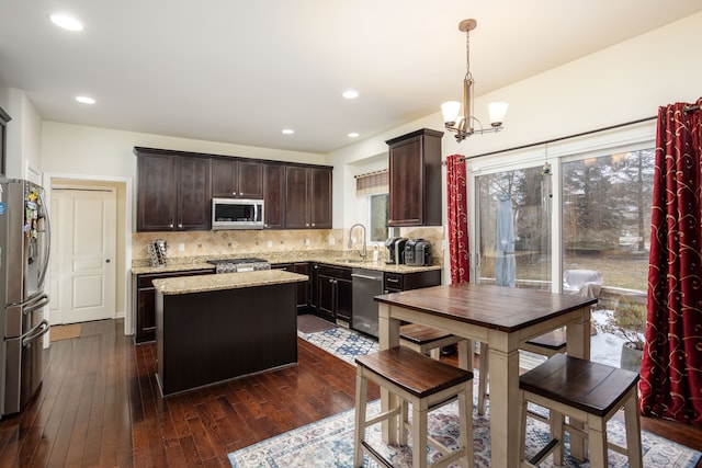 kitchen featuring a kitchen island, dark hardwood / wood-style floors, pendant lighting, sink, and stainless steel appliances