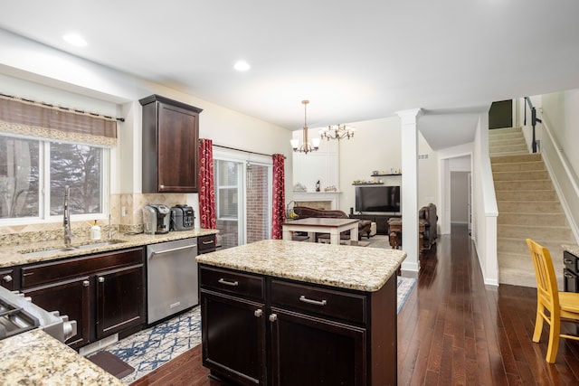 kitchen with sink, a center island, dark hardwood / wood-style flooring, dishwasher, and pendant lighting