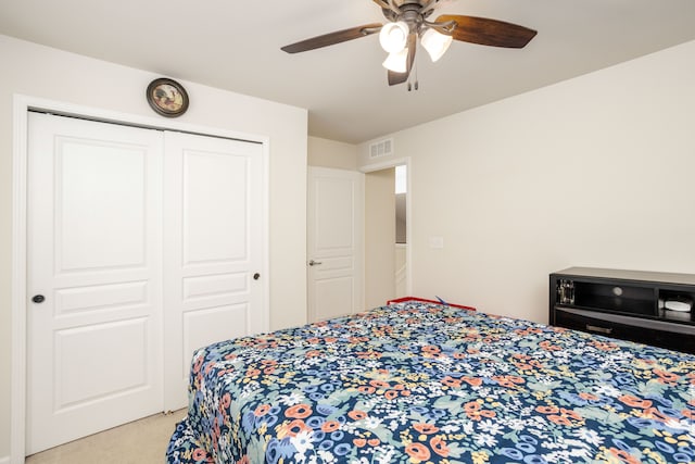 carpeted bedroom featuring a closet and ceiling fan