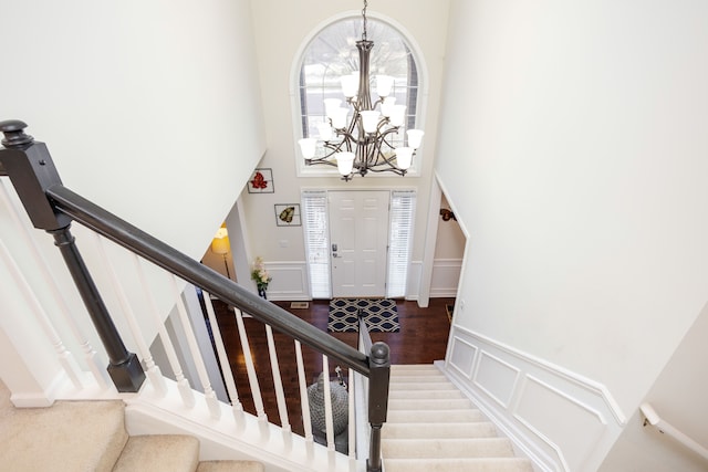 foyer entrance featuring a high ceiling, hardwood / wood-style flooring, and an inviting chandelier