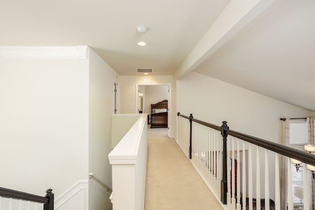 hallway with beamed ceiling and light carpet