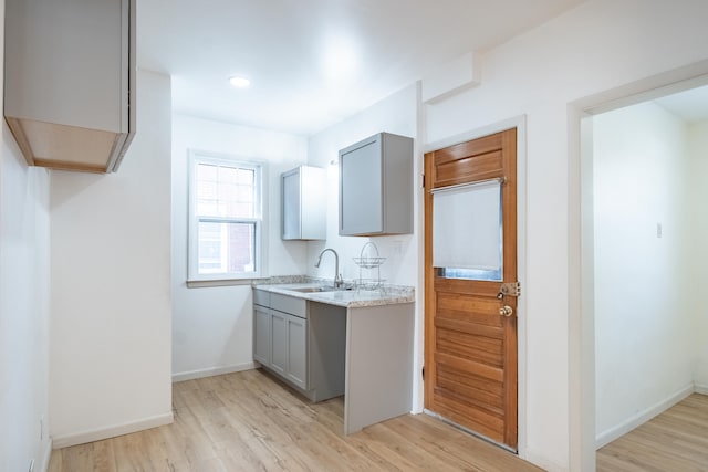 kitchen featuring gray cabinets, sink, and light hardwood / wood-style flooring