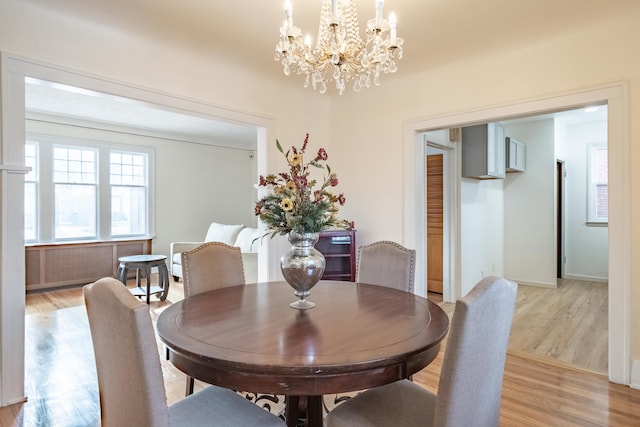 dining area featuring a notable chandelier and light wood-type flooring