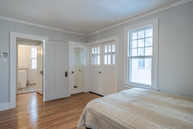 bedroom featuring multiple windows, crown molding, radiator, and light hardwood / wood-style floors