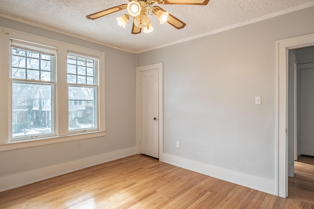 empty room featuring crown molding, ceiling fan, light hardwood / wood-style floors, and a textured ceiling