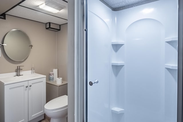 bathroom featuring vanity, a drop ceiling, and toilet