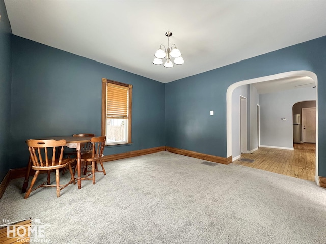 dining room featuring carpet flooring and a chandelier