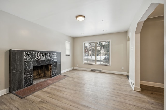 unfurnished living room with a premium fireplace and light wood-type flooring