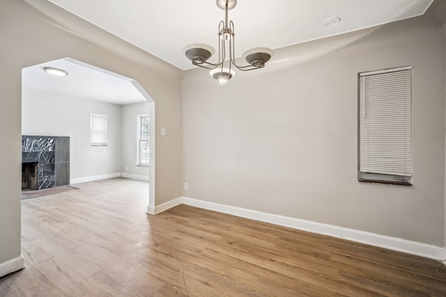 unfurnished dining area featuring a high end fireplace and light hardwood / wood-style floors