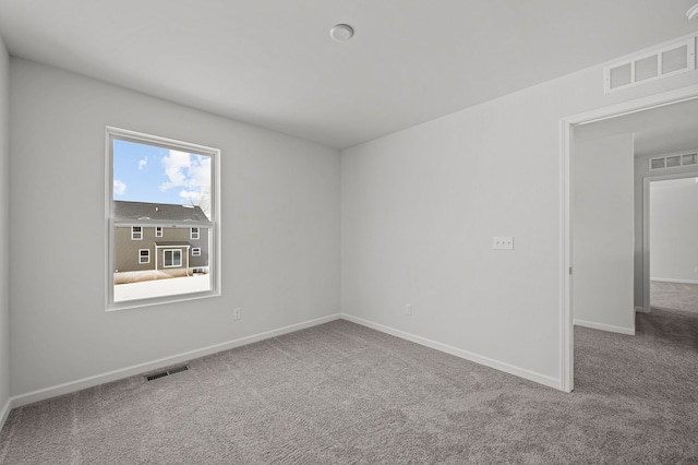 spare room featuring visible vents, baseboards, and carpet flooring