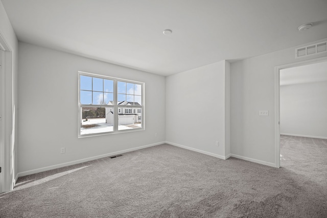 unfurnished room with visible vents, baseboards, and carpet floors