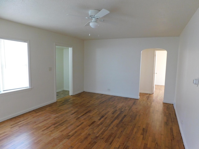 1336 Agard Ave, Benton Harbor, MI 49022 - unfurnished room with ceiling fan, arched walkways, baseboards, and wood finished floors