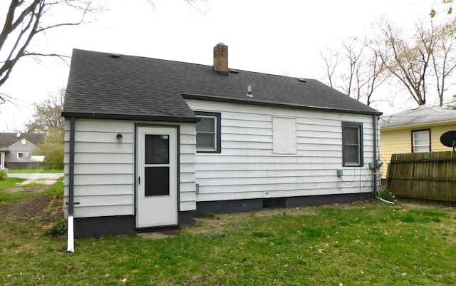 1336 Agard Ave, Benton Harbor, MI 49022 - back of property with a yard, fence, a chimney, and roof with shingles