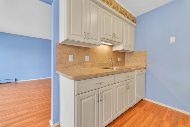 kitchen with sink, dishwasher, white cabinetry, backsplash, and light hardwood / wood-style floors