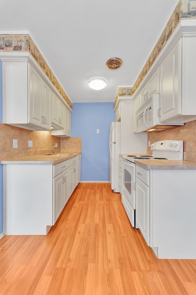 kitchen featuring white appliances, sink, light hardwood / wood-style flooring, and white cabinets