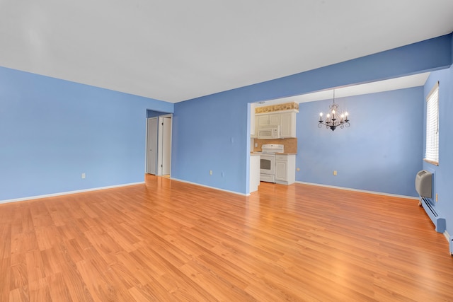 unfurnished living room with a notable chandelier, a wall mounted air conditioner, and light hardwood / wood-style floors