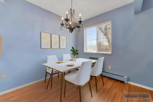 dining area featuring a baseboard heating unit and light hardwood / wood-style floors