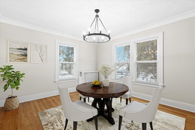 dining area with hardwood / wood-style flooring, plenty of natural light, and a chandelier