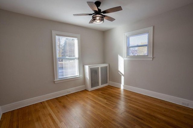 empty room with ceiling fan and light hardwood / wood-style flooring