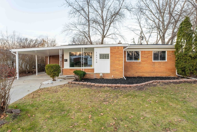 ranch-style house featuring a front lawn and a carport