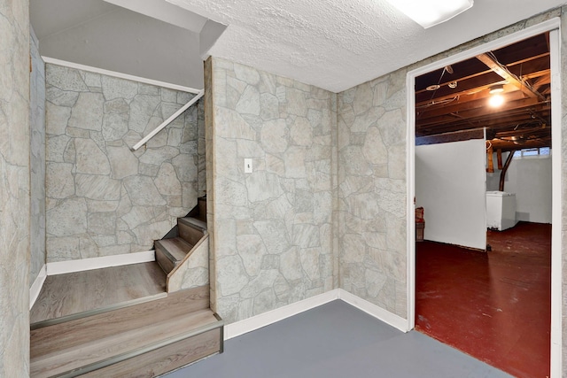 staircase with concrete flooring and washer / clothes dryer