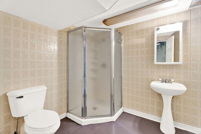 bathroom featuring tile patterned floors, a shower with door, and toilet