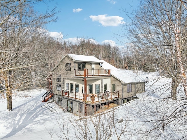 snow covered rear of property with a balcony