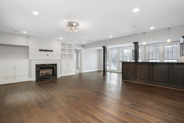 31265 Woodside Dr, Franklin, MI 48025 - unfurnished living room with built in features, decorative columns, dark wood-style floors, recessed lighting, and a premium fireplace