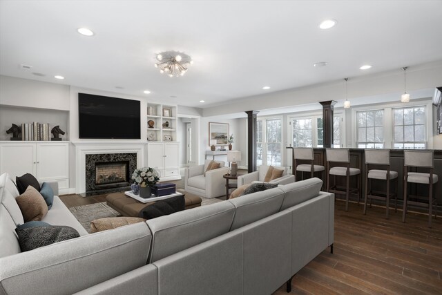 31265 Woodside Dr, Franklin, MI 48025 - living room featuring dark wood-style flooring, ornate columns, recessed lighting, and a fireplace