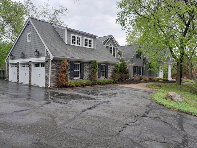 31265 Woodside Dr, Franklin, MI 48025 - new england style home featuring a garage, a shingled roof, driveway, and stone siding