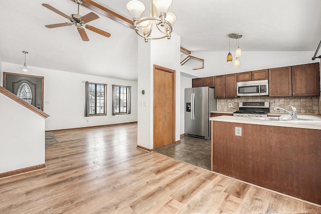 kitchen featuring vaulted ceiling with beams, appliances with stainless steel finishes, hanging light fixtures, and backsplash