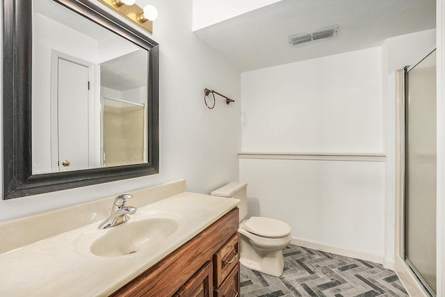 bathroom featuring vanity, toilet, and walk in shower