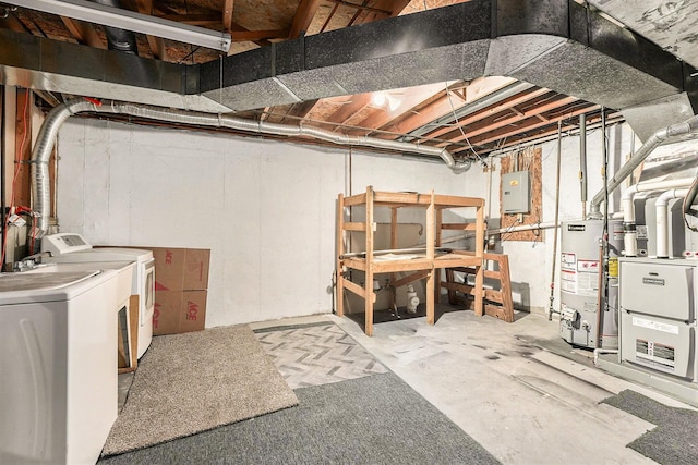 basement with gas water heater, washing machine and clothes dryer, and electric panel