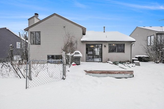 view of snow covered back of property