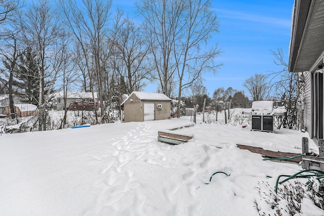 yard layered in snow featuring a shed