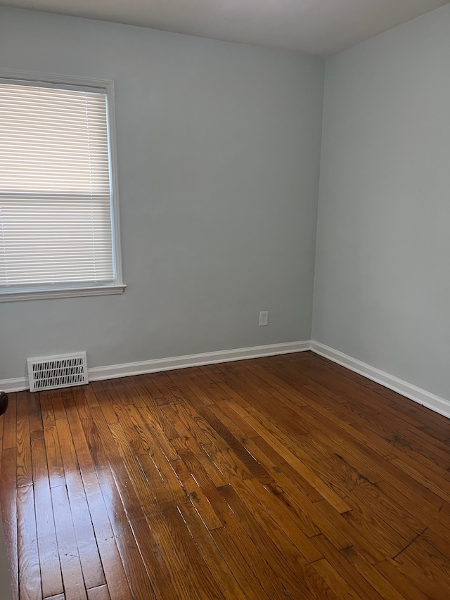 empty room featuring dark hardwood / wood-style flooring and a healthy amount of sunlight