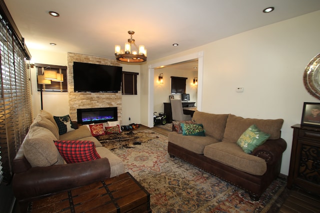 living room featuring an inviting chandelier, a fireplace, and wood-type flooring