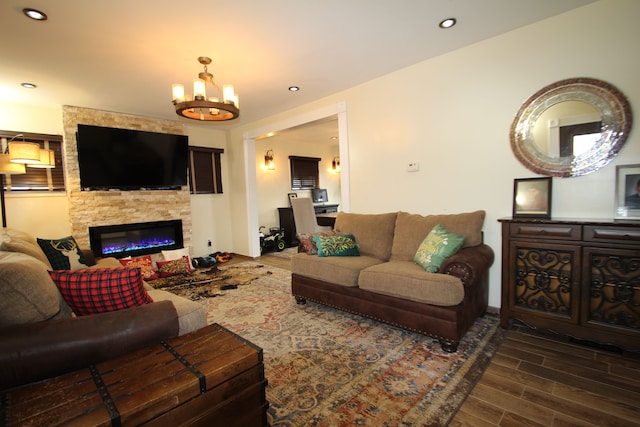 living room featuring a stone fireplace and a chandelier