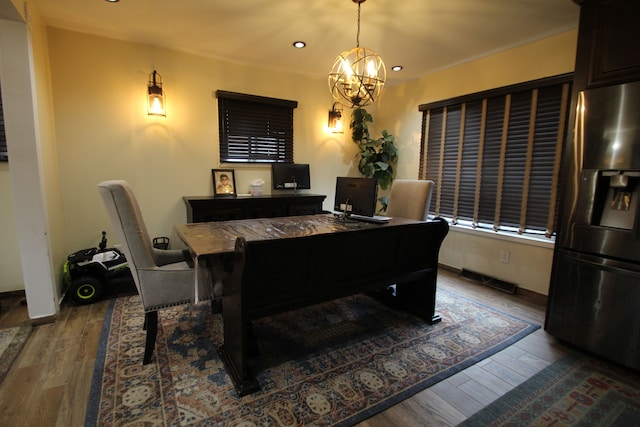 dining space with wood-type flooring and a chandelier