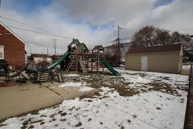 snow covered playground with a storage shed