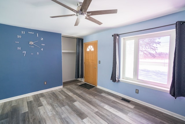 spare room with baseboards, visible vents, ceiling fan, and wood finished floors