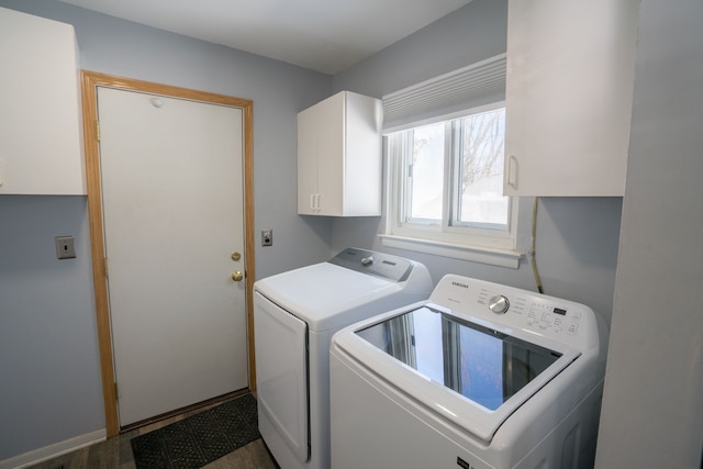 washroom with baseboards, washer and clothes dryer, and cabinet space