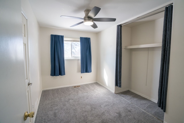 unfurnished bedroom with baseboards, a ceiling fan, visible vents, and carpet floors