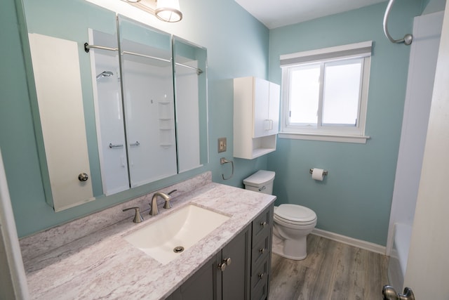 full bathroom featuring vanity, baseboards, wood finished floors, and toilet