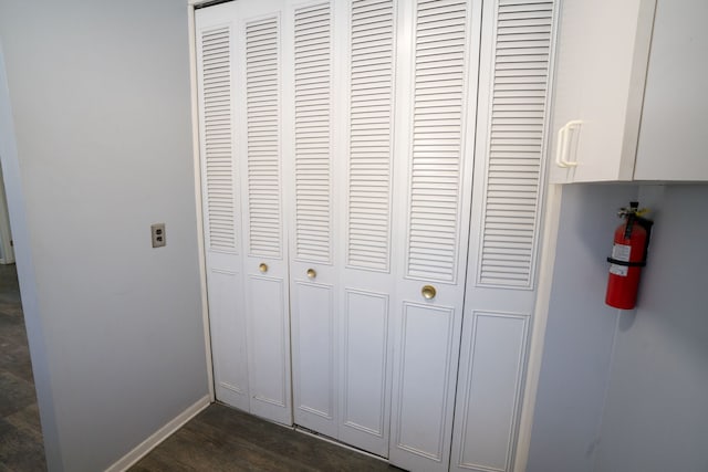 details with baseboards, a fire extinguisher, and wood finished floors