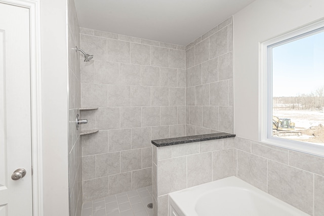 bathroom featuring a bath and tiled shower