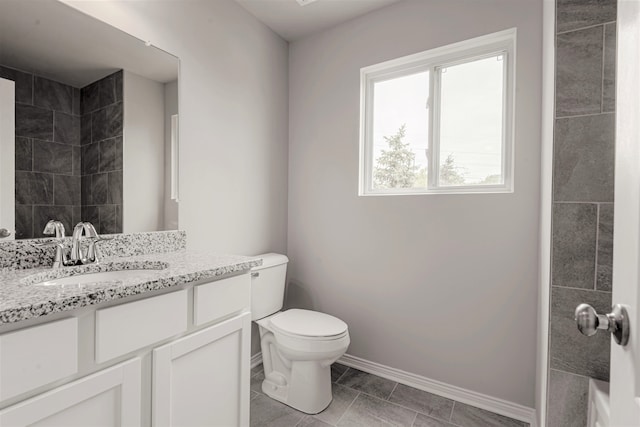 bathroom with toilet, tile patterned floors, baseboards, and vanity