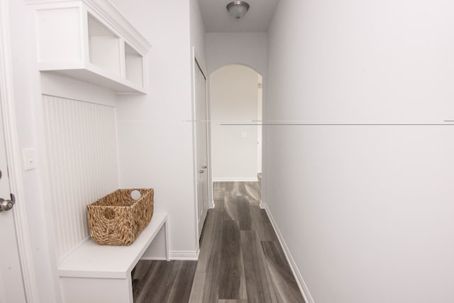 mudroom featuring dark wood-style floors, baseboards, and arched walkways